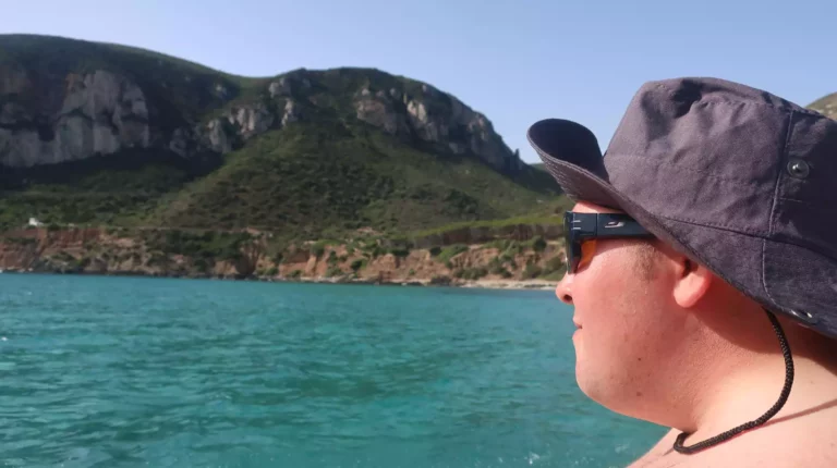 femme sur un bateau regardant la mer et la montagne